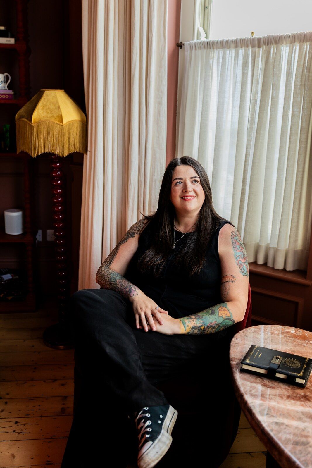 Hannah Wild seated in an armchair by a bright window