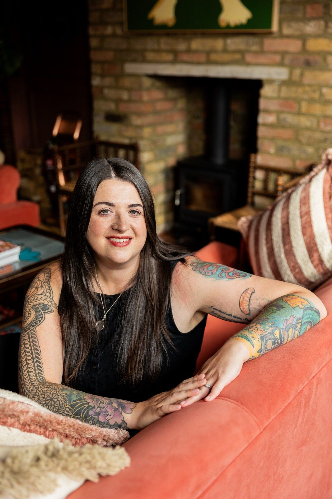 Hannah Wild smiling warmly from a sofa in her counselling room